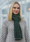 Woman wearing a green scarf and cap in an urban setting
