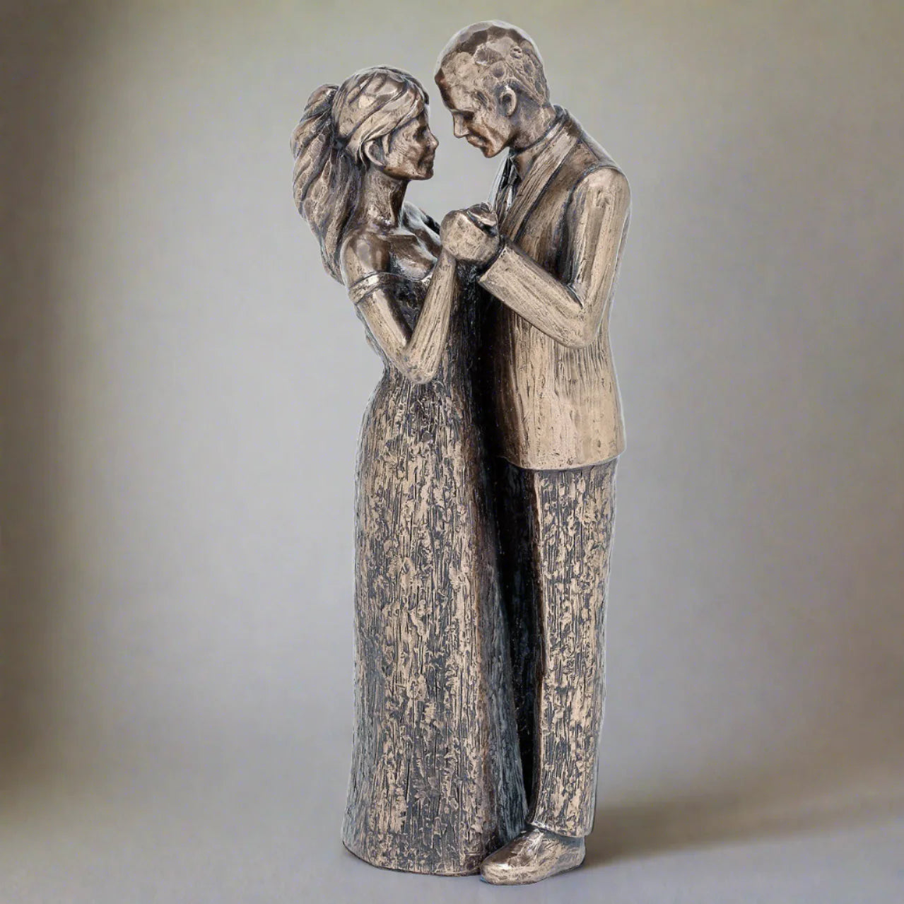 Statue of a couple in a romantic pose on a plain background