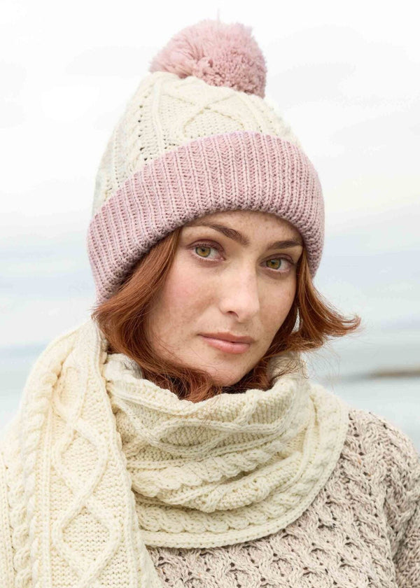 Woman wearing a knitted hat and scarf by a body of water