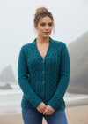 Woman wearing a teal knitted cardigan on a white background
