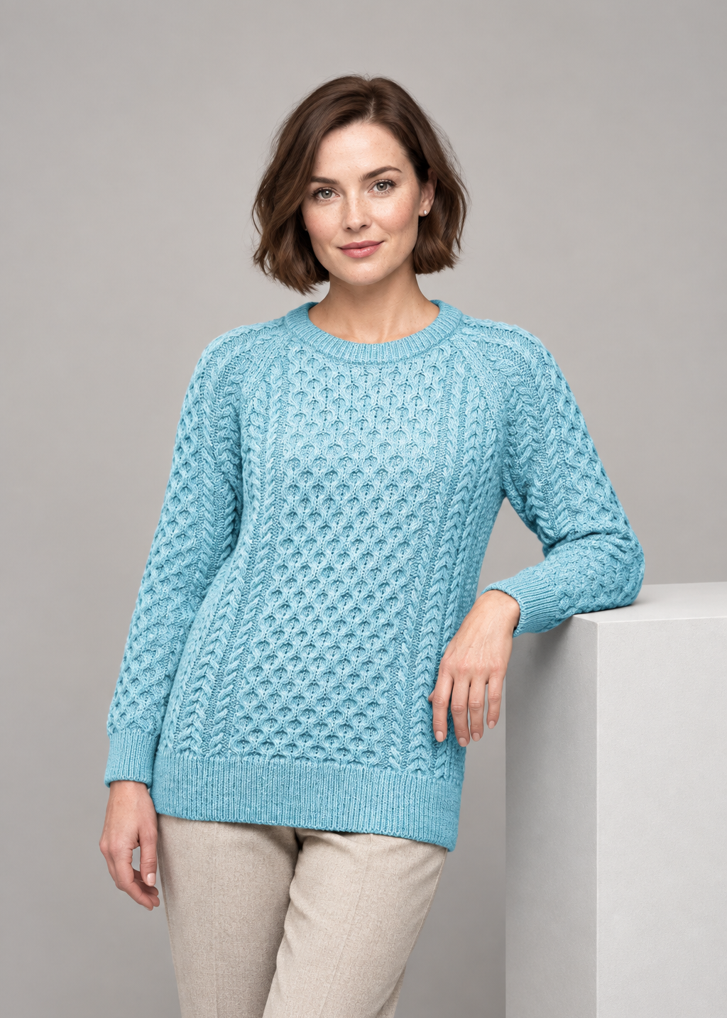 Aqua sweater leaning on studio plinth