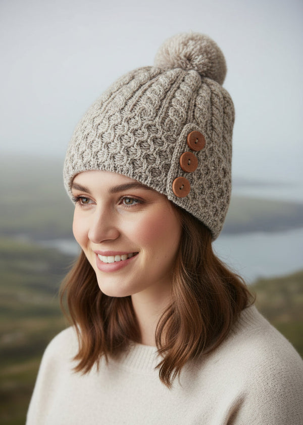 Knitted beanie with buttons and a pom-pom on a white background