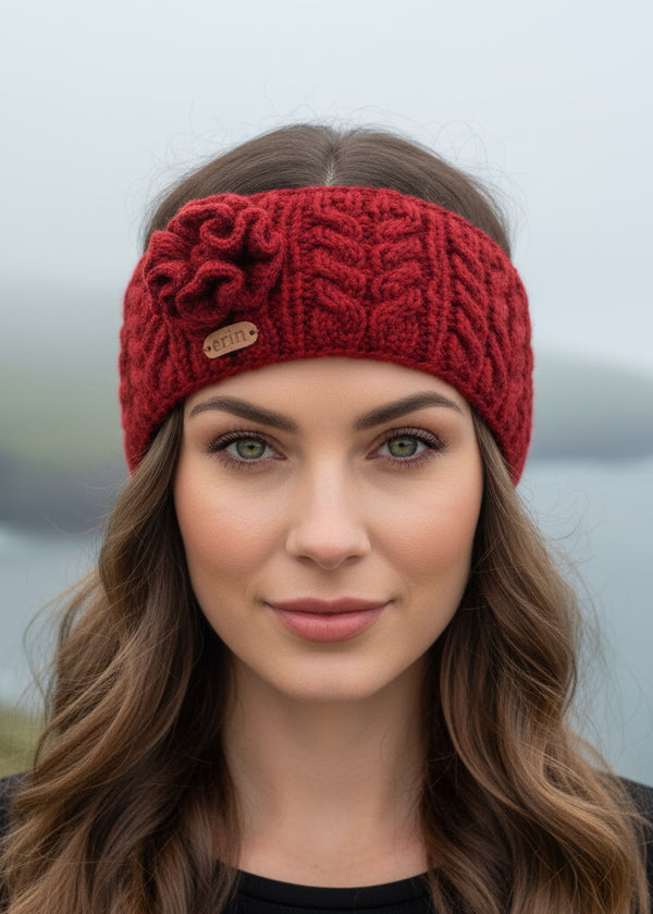 Red knitted aran headband with a flower on a white background