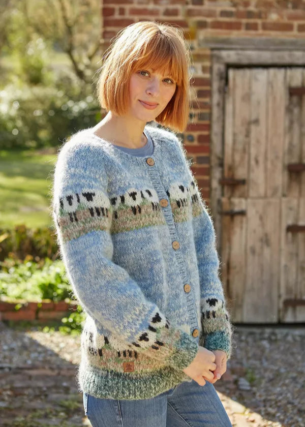 Woman wearing a patterned sweater standing outdoors with a rustic background