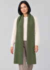 Green scarf over Aran knitwear, stepping pose