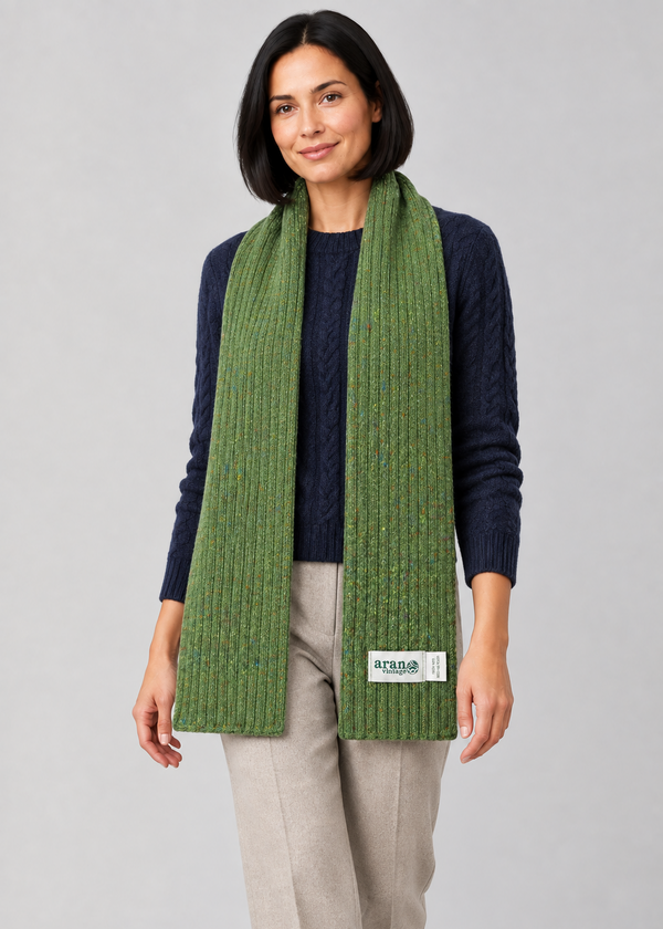 Green scarf over Aran knitwear, stepping pose