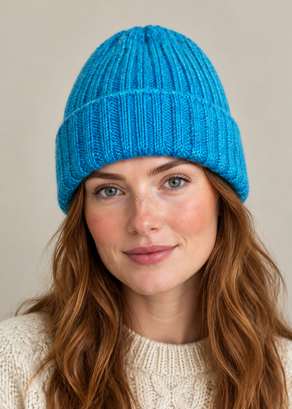 Female model wearing the blue 100% Donegal wool turn-up beanie hat, head and shoulders shot
