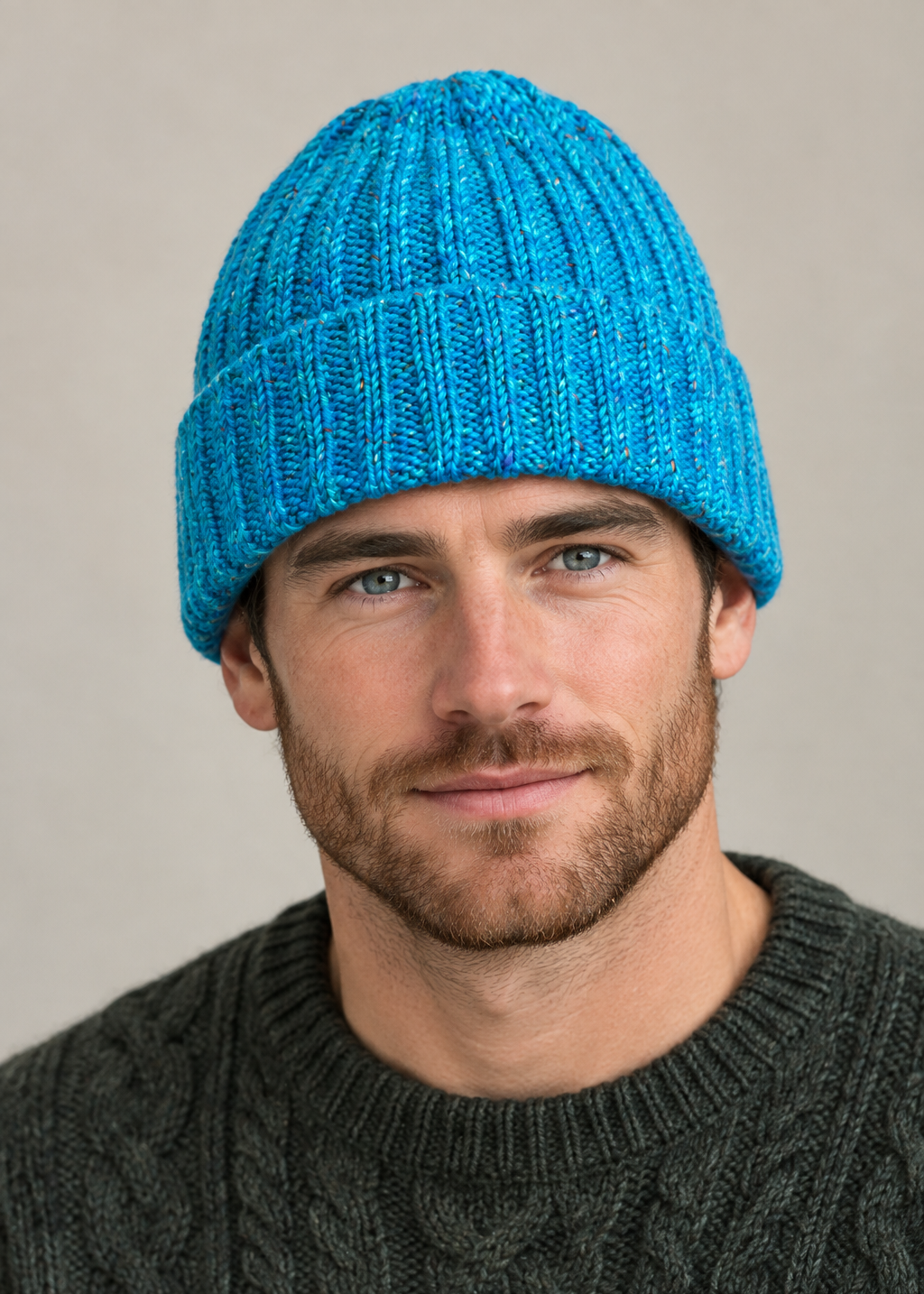 Male model wearing the blue 100% Donegal wool turn-up beanie hat, head and shoulders shot