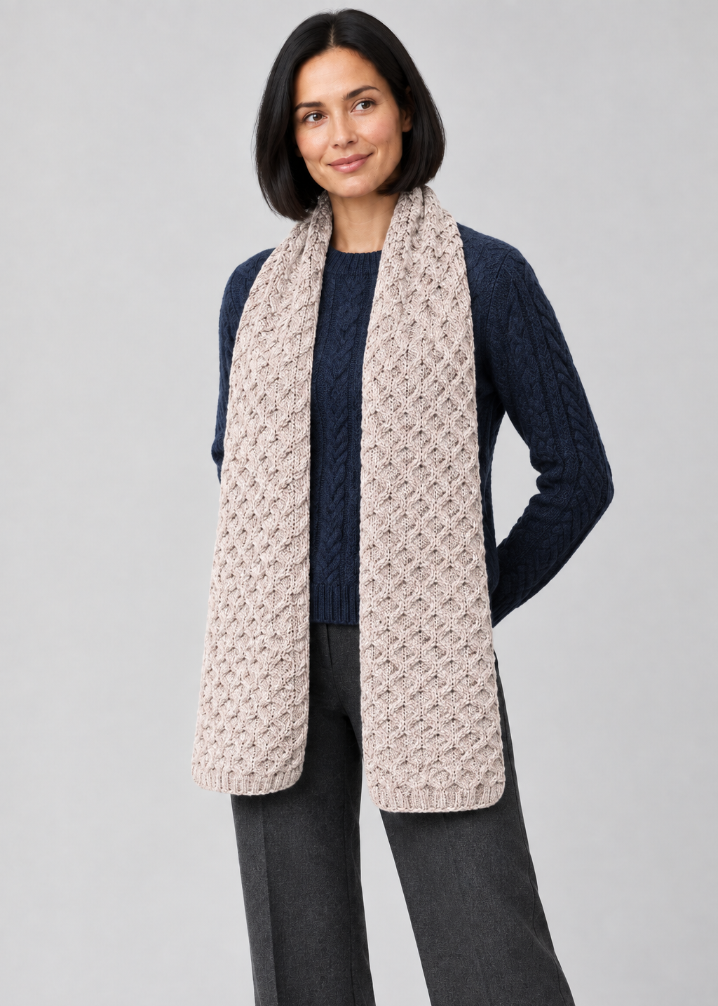 Scarf over navy Aran knitwear, angled pose