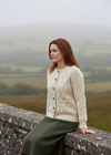 Sitting on stone wall-Ladies Aran Cardigan | 100% Irish Wool | Natural Cream